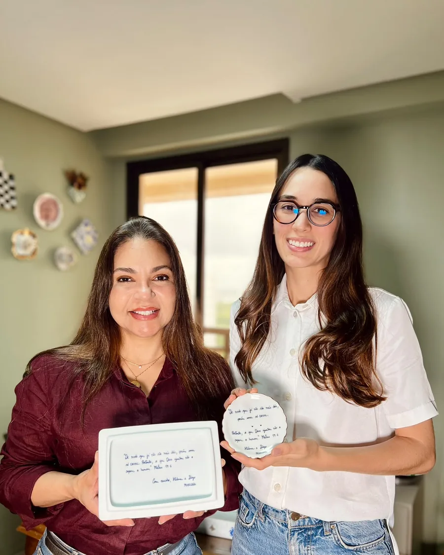 Katia e a noiva Milena mostrando a caixa retangular aberta com o versículo escrito por dentro