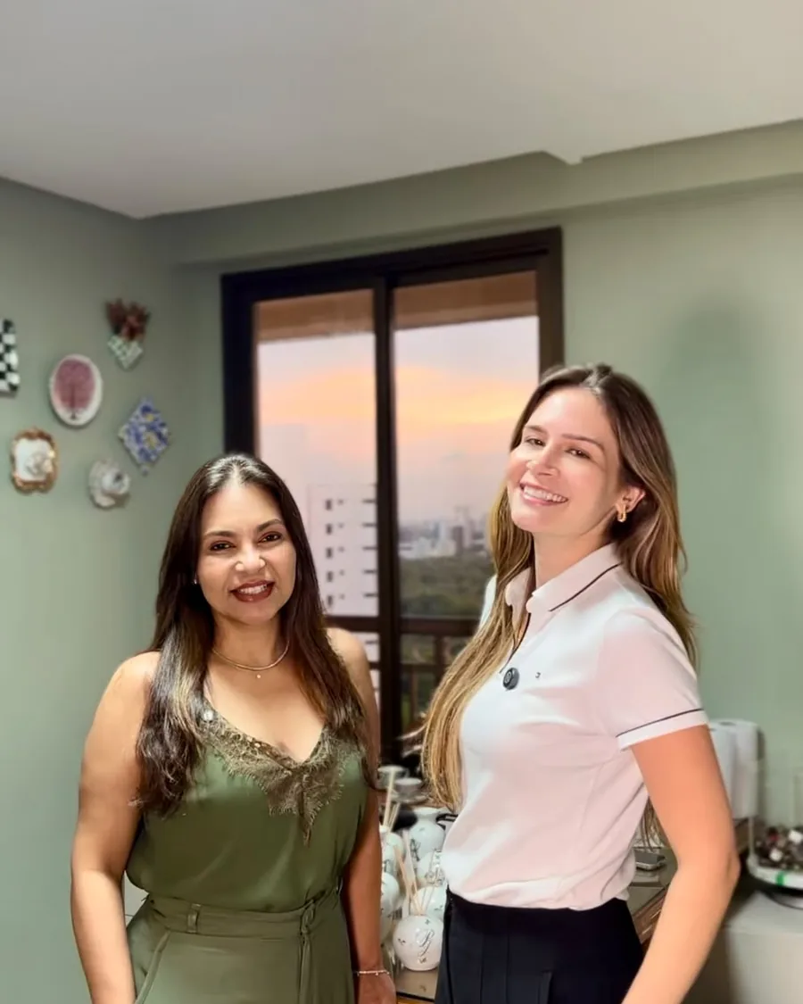 Katia e a noiva Paulinha lado a lado no ateliê, com pratos decorativos na parede